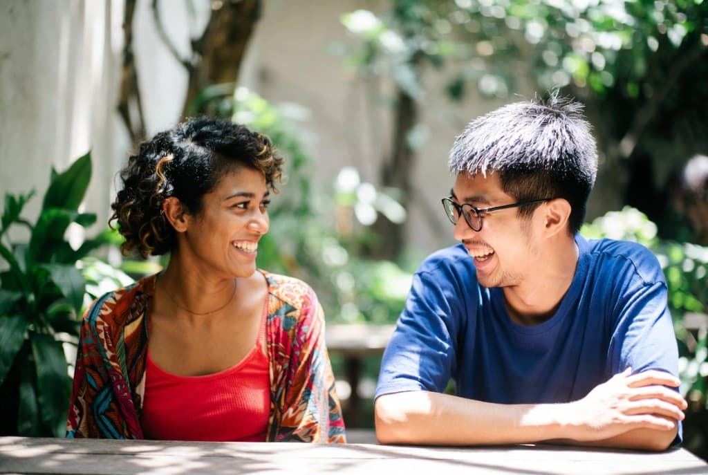 שני אנשים משוחחים באווירה חברית בחוץ